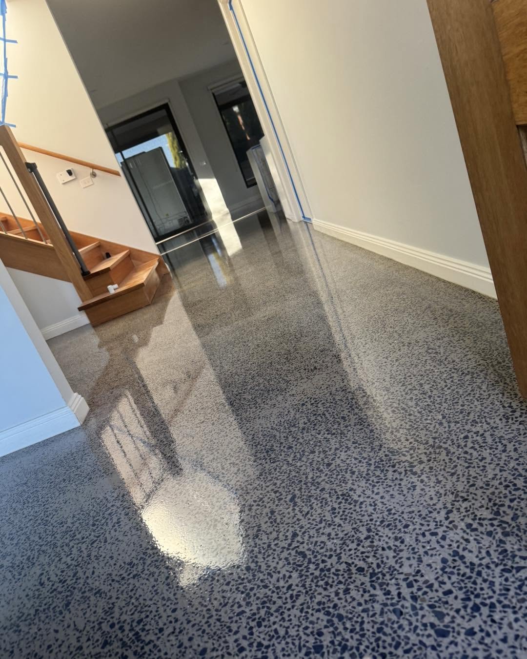 Speckled blue-grey epoxy flake floor flowing through a residential interior